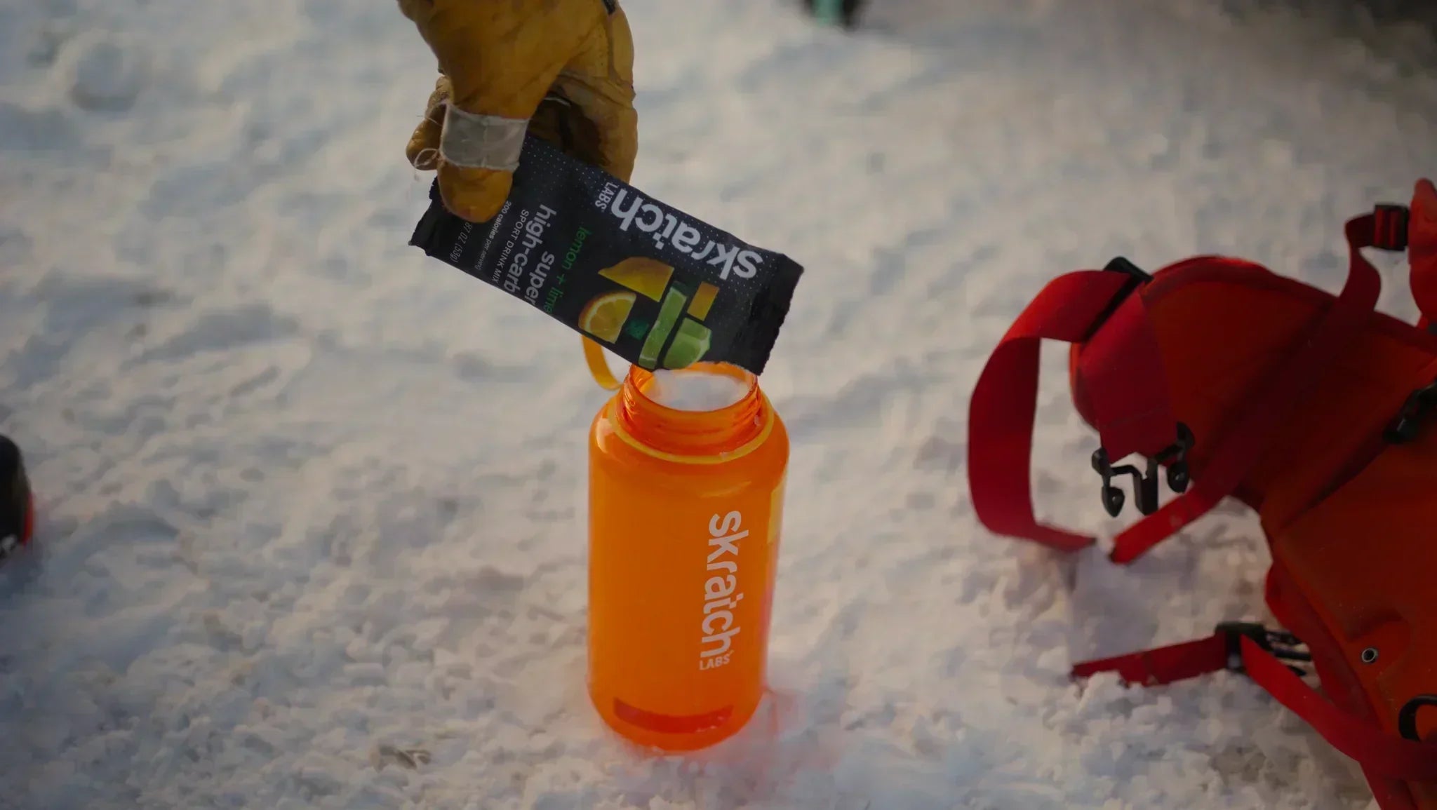 water bottle with high carb mix pouring in it in the snow