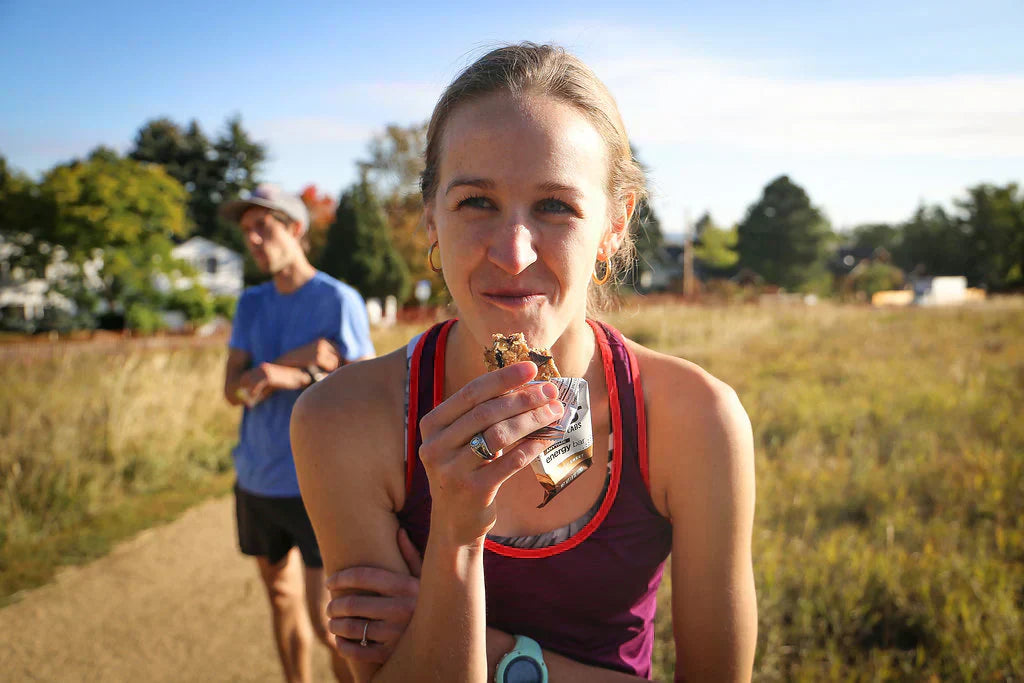 runner eating a bar on trail