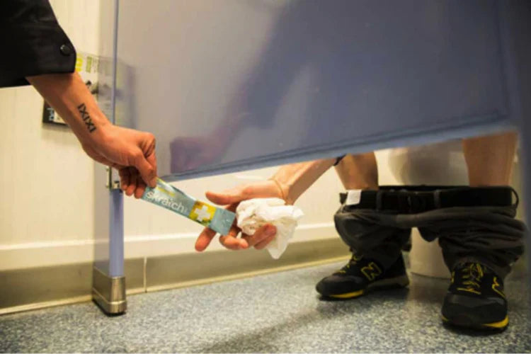 Handing a packet of hydration to someone in the bathroom